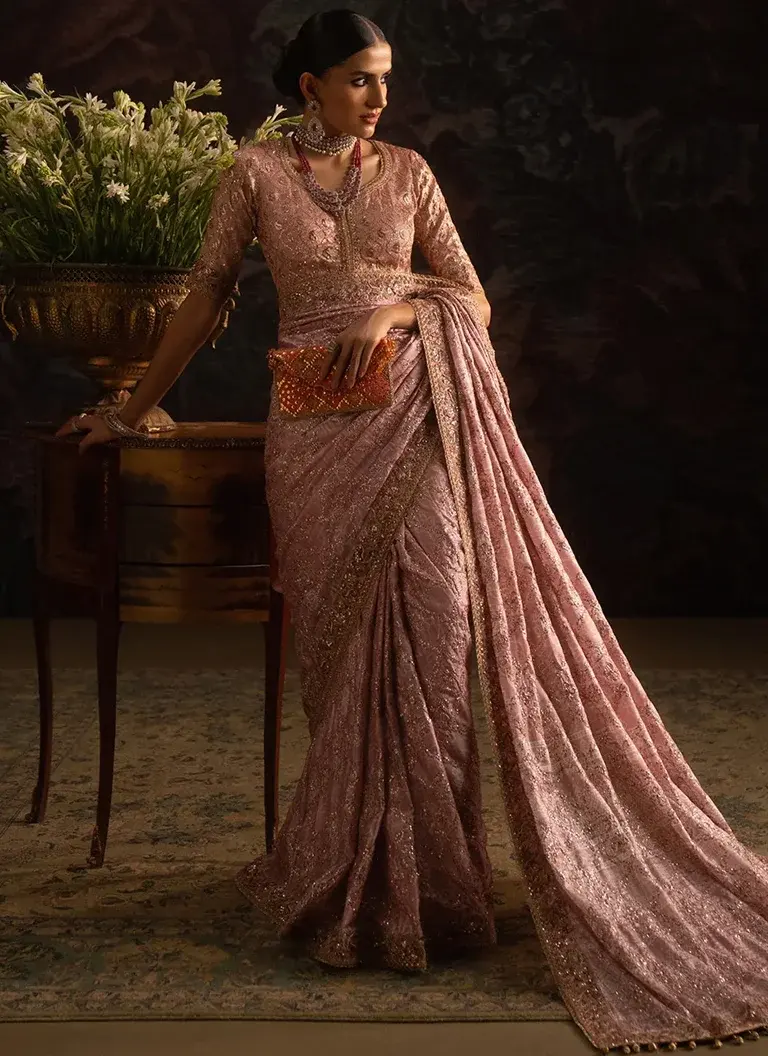 Pink net saree with matching embroidered blouse, sequin embellishments and elegant styling for weddings and formal occasions