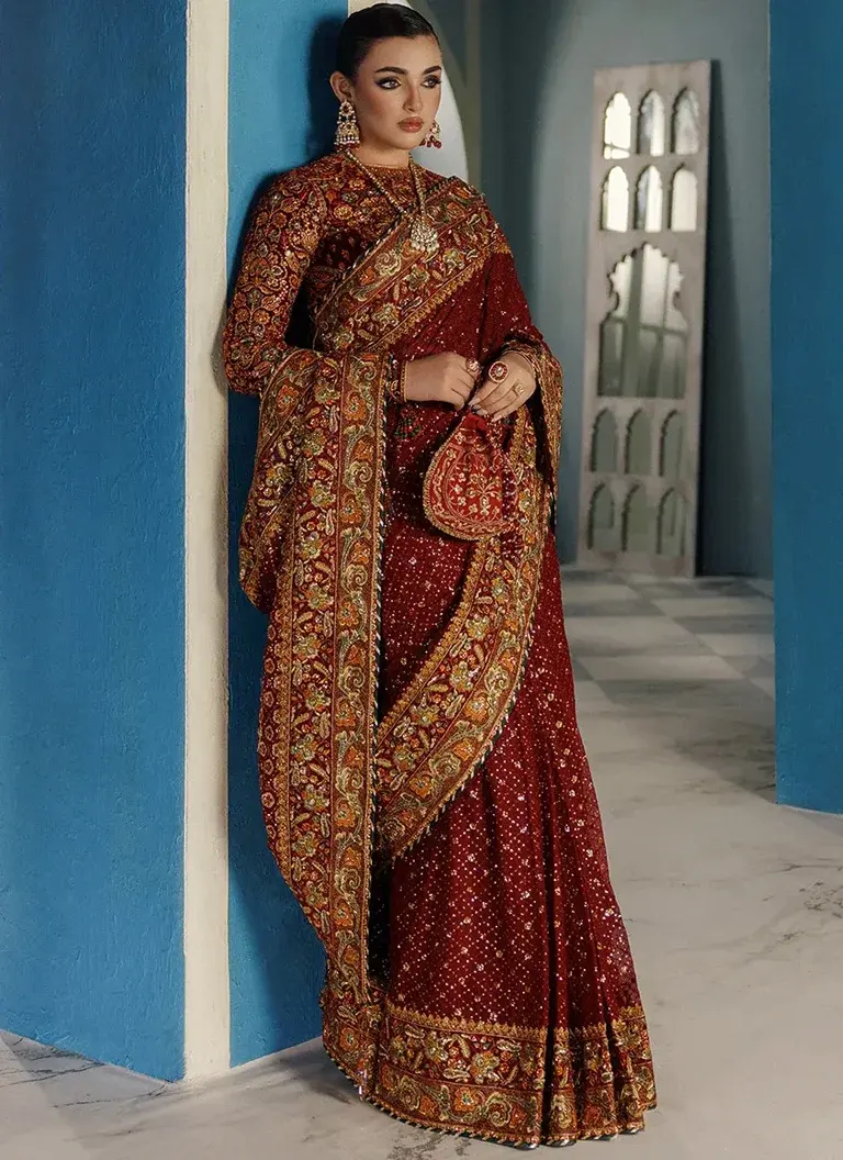 Pakistani burgundy wedding guest saree featuring embroidered chiffon pallu, intricate hand embroidery and elegant tassel detailing
