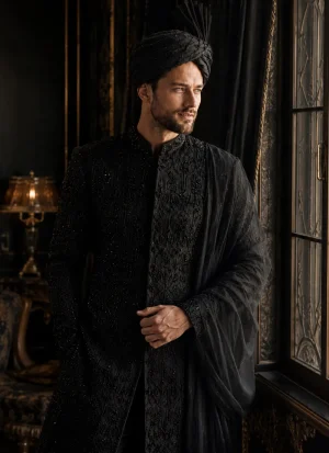 Groom wearing a black sherwani with a matching black turban and shawl