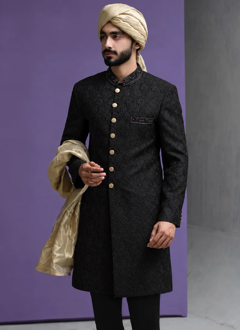 Black groom sherwani styled with a gold shawl and turban for a traditional wedding look