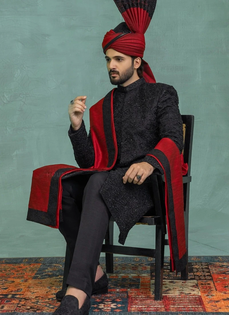 Black groom sherwani styled with a red shawl and turban for a traditional Pakistani wedding look