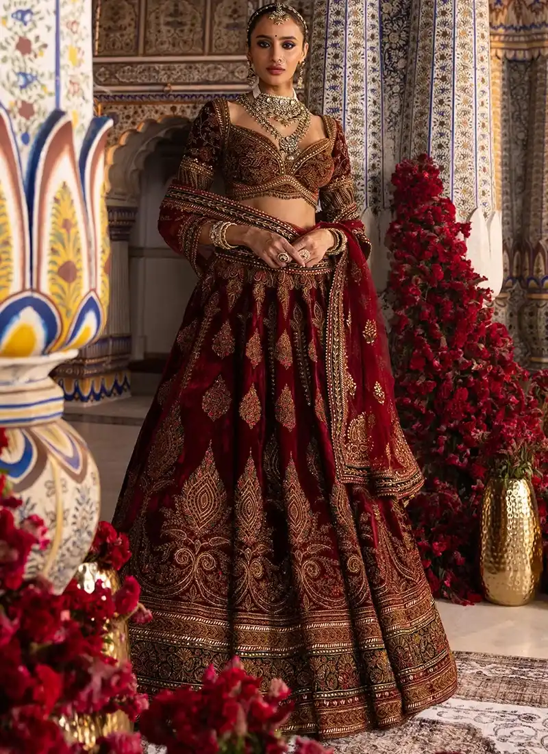 Deep Maroon Indian Velvet Bridal Lehenga Choli Deep maroon velvet bridal lehenga featuring antique gold paisley embroidery and traditional detailing