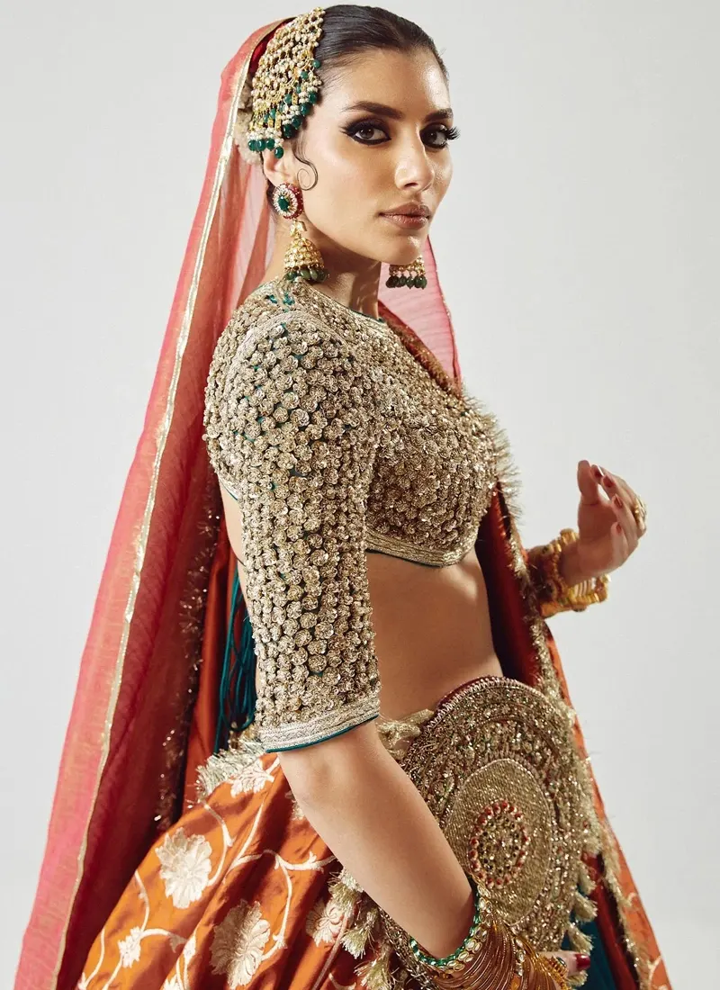 Zinc blue lehenga choli with dense metallic rounds and florets on the blouse and a scalloped embroidered hem