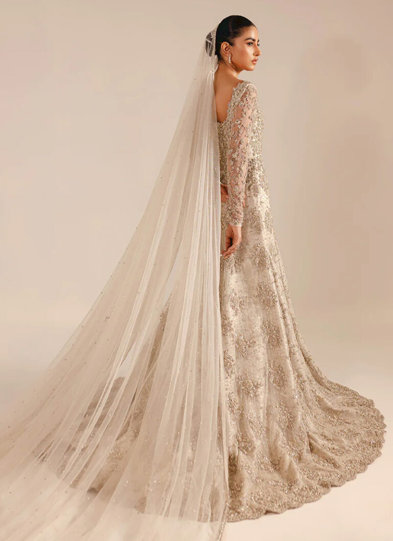 Ivory bridal gown with long train crafted in net and silk with graceful wedding styling