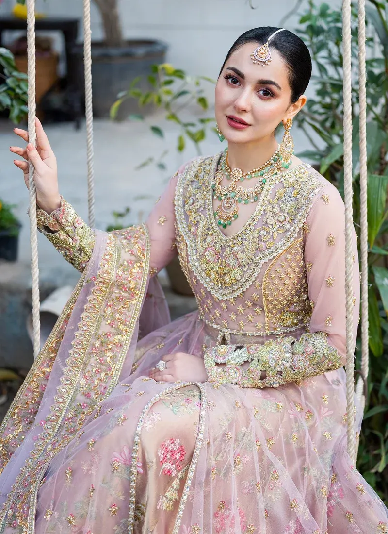 Baby pink bridal open gown and Atlas lehenga with scattered gold sprigs, pink and green blooms and attached cancan