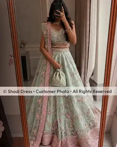 Shadi Dress Kundin in einem mintgrünen pakistanischen Lehenga für Hochzeitsgäste mit rosa Stickerei