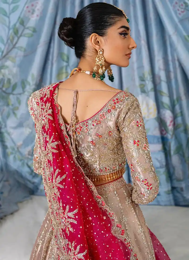 Rose beige bridal lehenga choli rear full-length view with wide embroidered hem and sweeping fuchsia dupatta