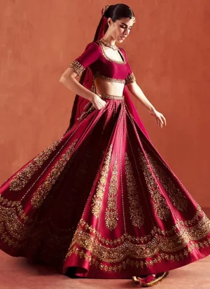 Deep red bridal lehenga choli from the back, showing a deep rounded cut-out and antique gold floral embroidery.