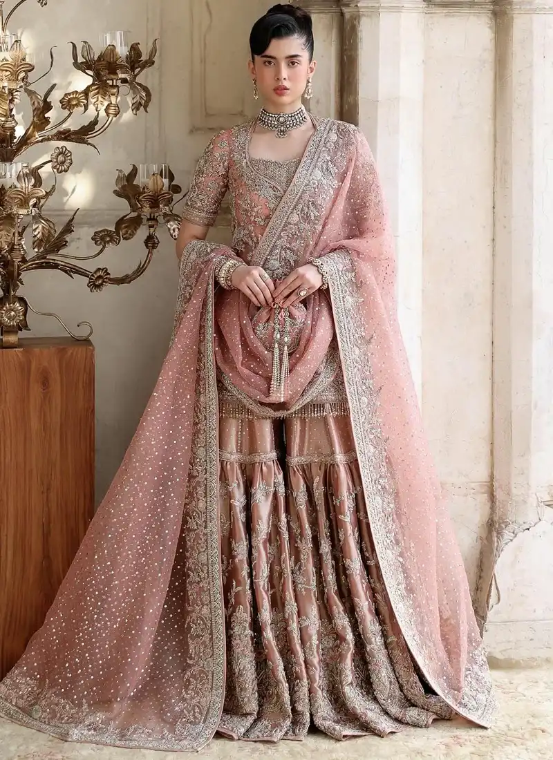 Dusty Pink Walima Gharara Suit with Chevron Back Embroidery Dusty pink bridal gharara seated front view with floral embroidered dupatta and ornate metallic borders.