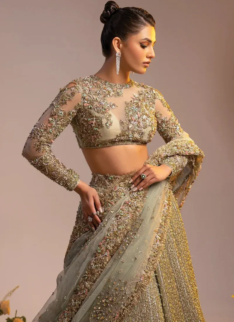 Gold lehenga choli rear three-quarter view showing sequined skirt and sheer sage dupatta