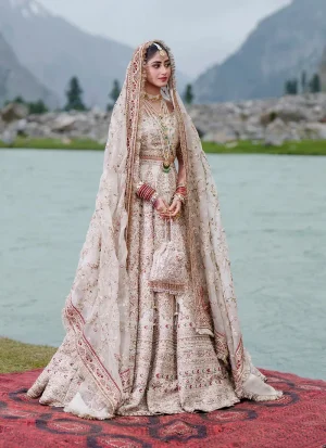 Full-length standing view of the ivory Baraat lehenga choli: cropped embellished choli, wide embroidered ghera and sheer dupatta with maroon kiran-lace borders