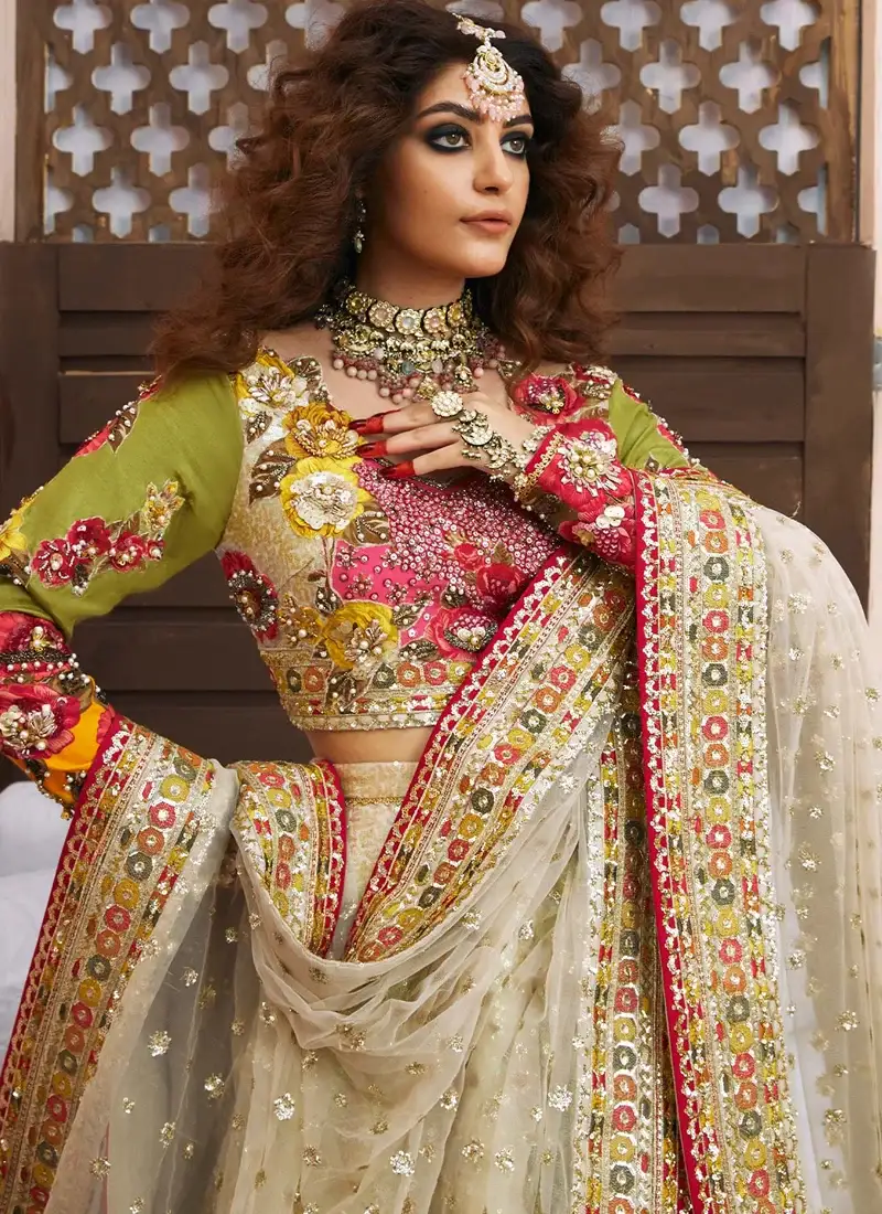 Ivory bridal lehenga choli front view with multicolour floral embroidery and orange teardrop hem
