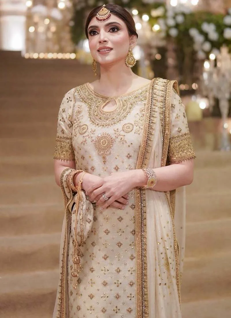 Ivory formal three-piece suit, side view highlighting gold embroidered sleeves and flowing bordered dupatta