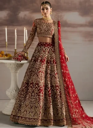 Maroon bridal lehenga choli, full-length angled view with tiered gold floral arches and sheer red dupatta