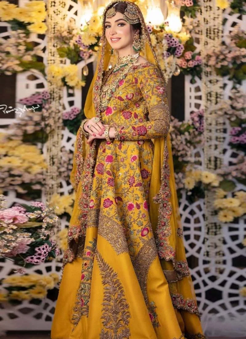 Mustard gold bridal lehenga three-quarter view with floral embroidery, ornate skirt panels and bordered dupatta