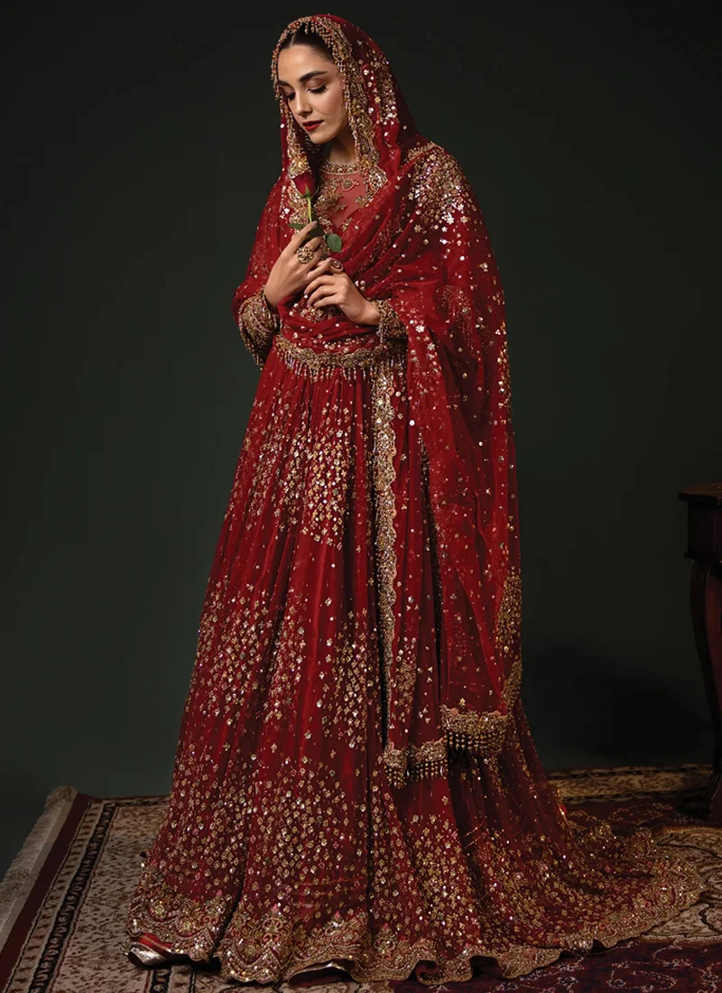 Red bridal pishwas close-up showing gold floral zardozi on the sheer yoke and ornate long-sleeve cuffs