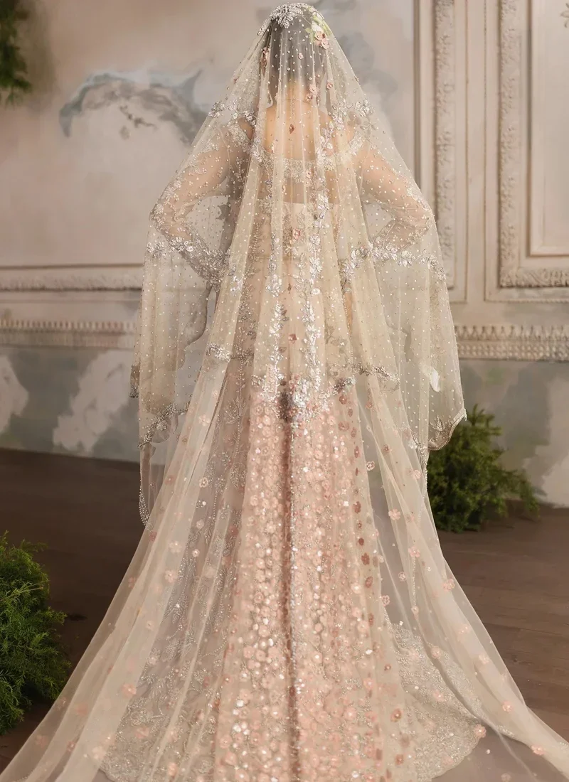 Peach bridal gown angled side view with fitted waist, sheer embroidered sleeves and silver floral vines
