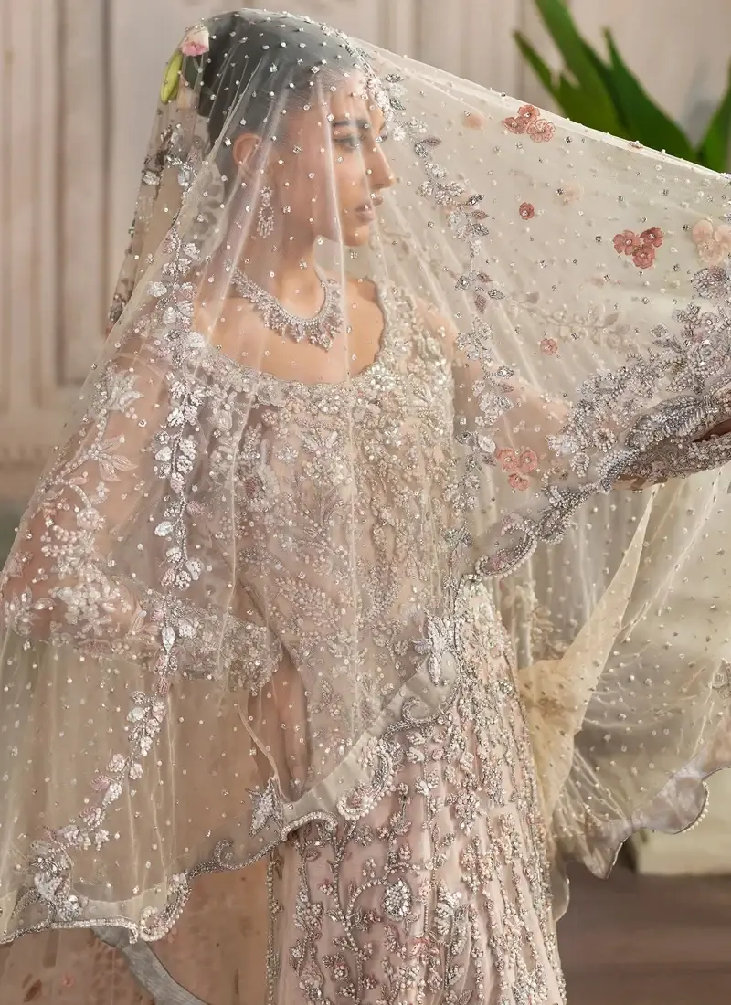 Peach bridal gown back view beneath a flowing sheer net veil with pink flowers and silver embroidered borders