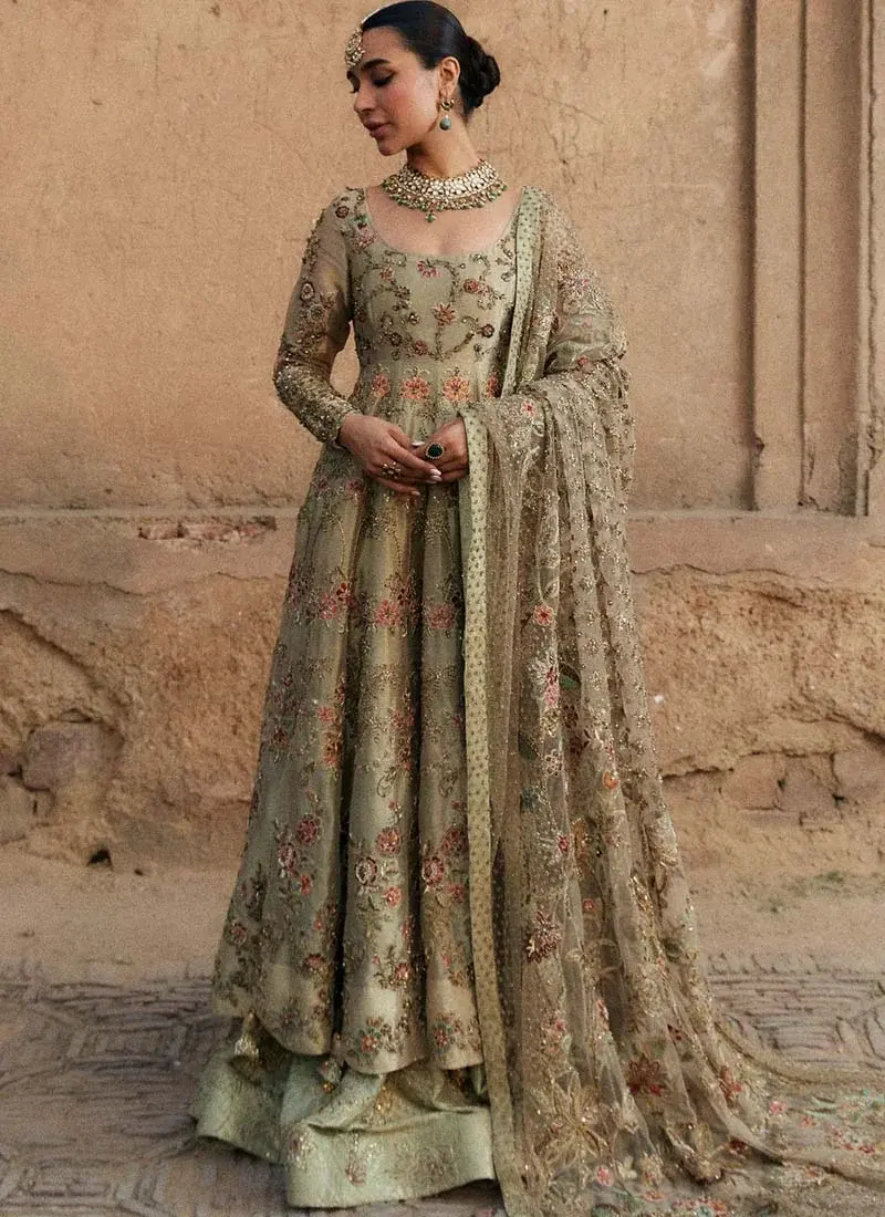 Sage Green Mehndi Pishwas with Beaded Back Tassels Sage green bridal pishwas side view with pink floral embroidery above a patterned brocade lehenga