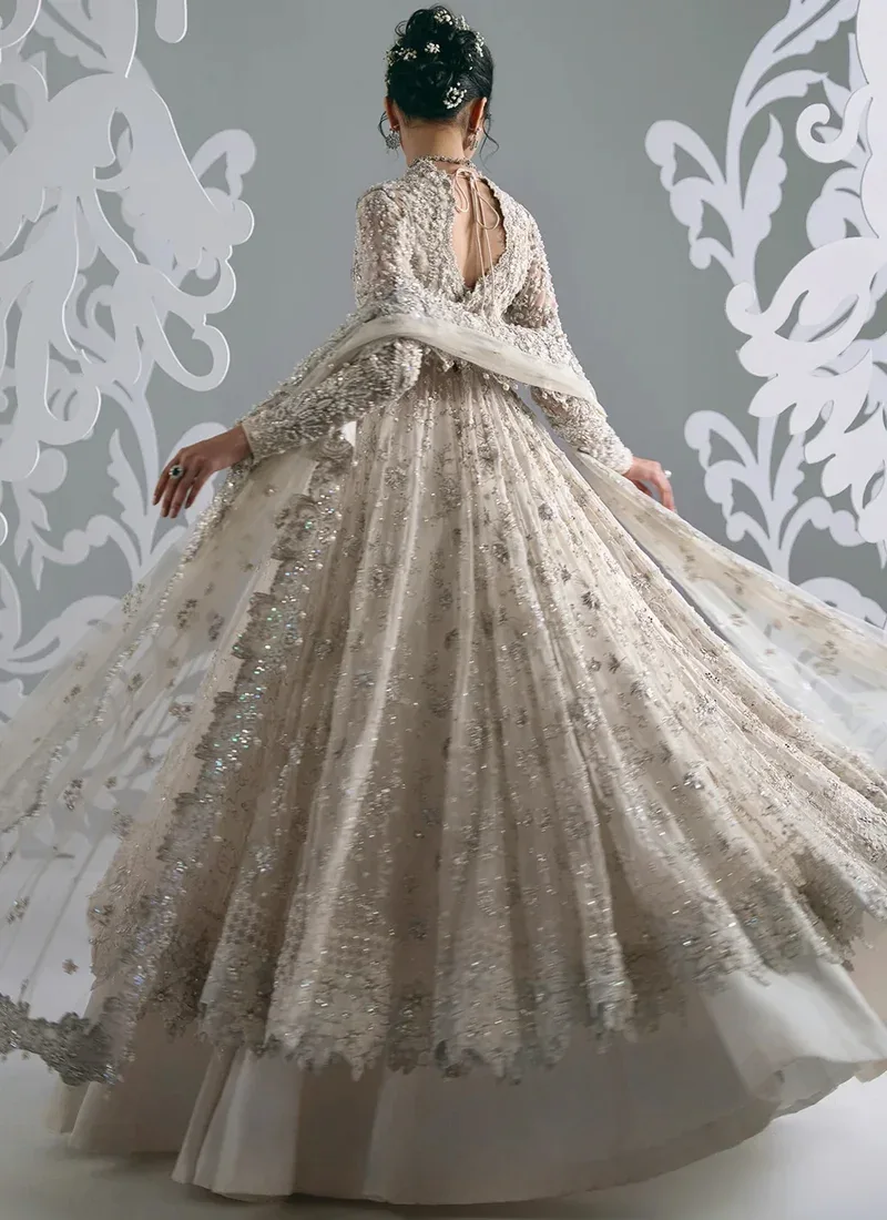 White bridal frock close-up showing scoop neckline, pearl beading and sheer embroidered full sleeves