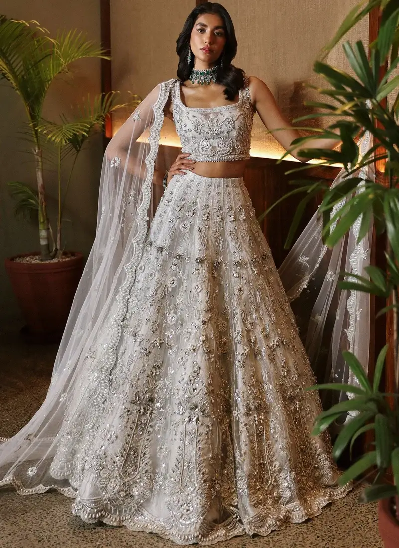 White Nikkah Frock with Lehenga with Scalloped Floral Hem White bridal lehenga choli seated front view with silver floral embroidery and scalloped hem