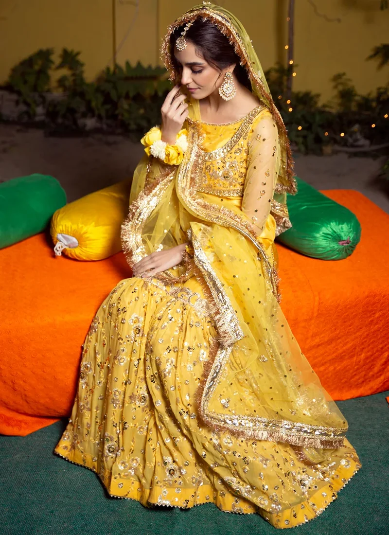 Yellow Mehndi Gharara Suit with Floral Vine Koti Yellow mehndi gharara suit back close-up showing gold floral embroidery and sheer embellished sleeves
