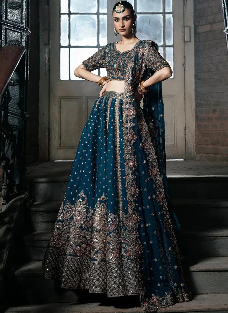 Zinc Blue Walima Lehenga Choli with Paisley Lattice Hem Zinc blue bridal lehenga choli side view with vertical embroidered panels and ornate floral paisley motifs